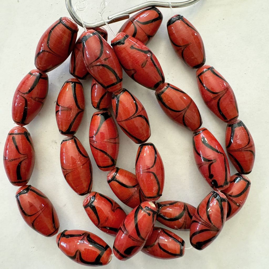 swirling lines motif glass, pale red black, 24x12mm bowed tube, 9 piece strand, sold per strand