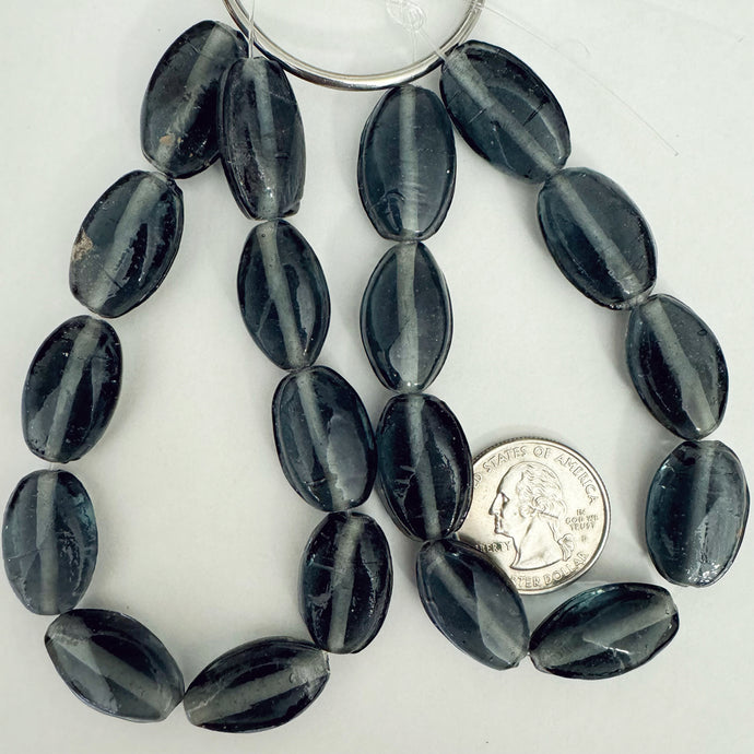 glass, translucent dark blue gray, 21x13x9mm puff twist oval, 9 piece strand, sold per strand