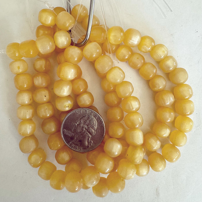 faux amber resin, pale pearly yellow, 10mm barrel, 24pc strand, sold per strand