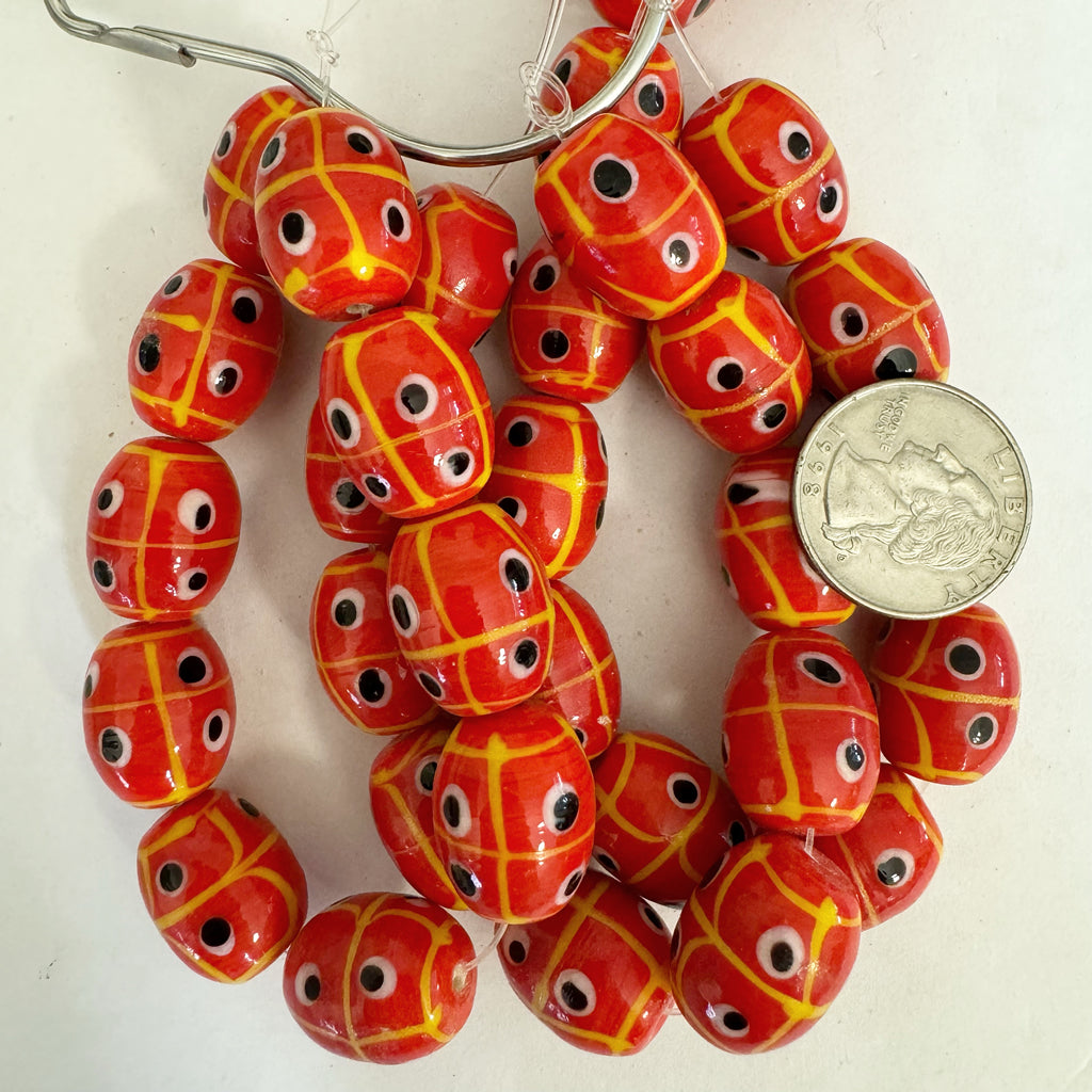 lines dots eyes motif glass, pale red  yellow black white, 20x17mm barrel, 10 piece strand, sold per strand