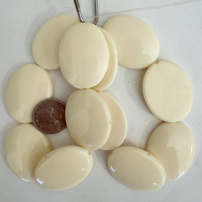 resin,  off white, 39x31x7mm puff oval domed one side flat one side, 2 direction drilled, 6pc strand, sold per strand