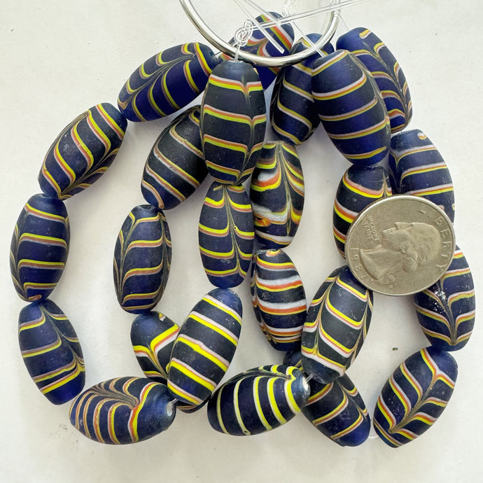 matte feathered lines motif glass, dark blue yellow white red, 27x14mm bowed tube, 8 piece strand, sold per strand