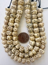 off white brown black, carved faces motif, vintage stock bone, 12x7mm rondelle, 11" strand, SOLD PER STRAND