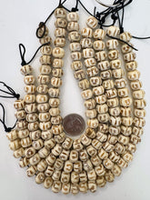 off white brown, carved face motif, vintage stock bone, 12x9mm rondelle, 11" strand, SOLD PER STRAND