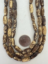 dark brown off white, dotted crossing lines motif, vintage stock bone, 18x7mm bowed tube, 15" strand, SOLD PER STRAND
