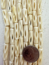 off white, carved open ovals motif, vintage stock bone, 25x7mm tube, 15" strand, SOLD PER STRAND