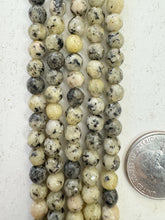color enhanced serpentine: pale yellow, 6mm faceted round, 15" strand,  SOLD PER STRAND