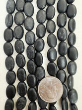 matte black stone, dull finish surface wear, 13x10x5mm oval, 15" strand, SOLD PER STRAND