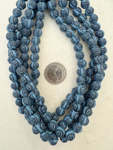 pale blue black, matte finish, carved buddha skull motif, vintage stock resin, 10mm round, 15" strand,  SOLD PER STRAND
