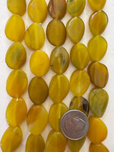color enhanced agate: amber yellow green, may have chipped or broken beads, 24x18x7mm twist oval, 15" strand,  SOLD PER STRAND