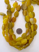 color enhanced agate: amber yellow green, may have chipped or broken beads, 24x18x7mm twist oval, 15" strand,  SOLD PER STRAND