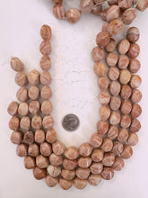 pale peach jasper, dull finish, 20x14x14mm carved twist barrel, 15" strand, sold per strand