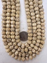 off white, carved dark crossing lines eye motif, vintage stock bone, 10x8mm rondelle, 15" strand, sold per strand