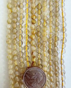 Golden rutilated quartz, 6mm round, 15" strand (mixed tone hank)